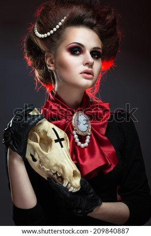 Girl in gothic art style with creative makeup and skull