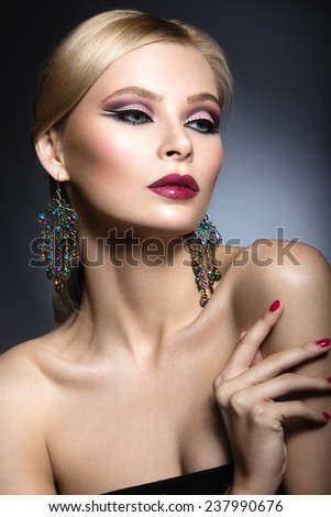 Beautiful girl with bright pink make-up and perfect skin. Beauty face. Festive image. Picture taken in the studio on a gray background.