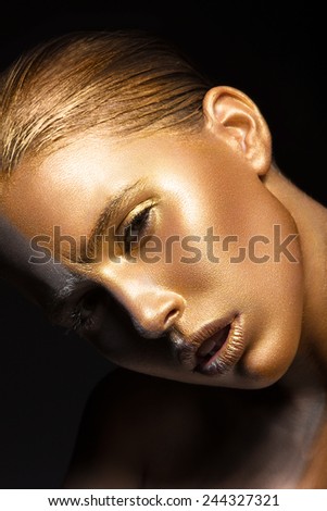 Beautyful girl with gold glitter on her face.Art image beauty face. Picture taken in the studio on a black background.