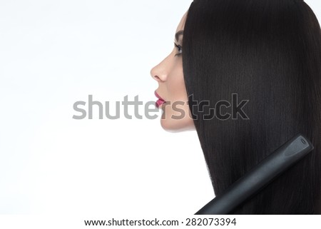 Beautiful brunette girl with a perfectly smooth hair, curling and classic make-up. Beauty face. Picture taken in the studio on a white background.
