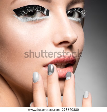 Beautiful girl with bright creative fashion makeup and Grey nail polish. Art beauty design.