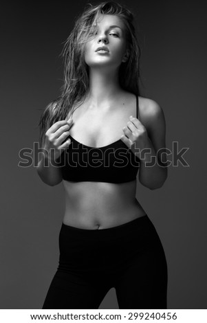 sexy fashion model with long hair, young European attractive, beautiful eyes, full lips, perfect skin is posing in studio for glamour vogue test photo shoot showing different poses.  Black and white