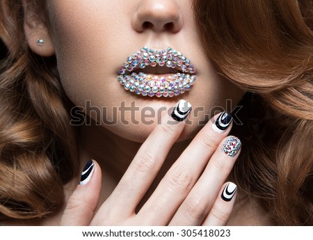 Beautiful girl with bright nails, lips of crystals, long eyelashes and curls. Beauty face.