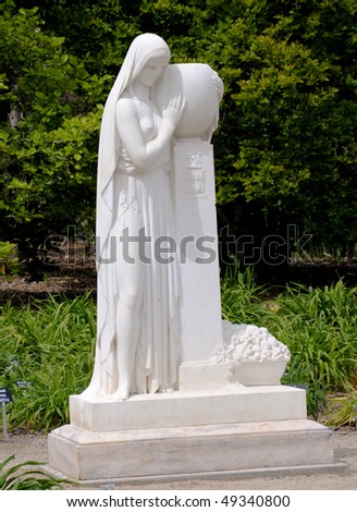 statue of a woman holding a vase with french inscription reading 