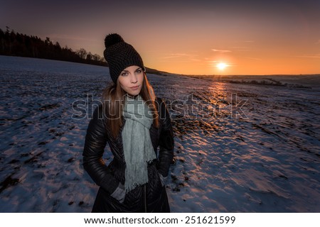 Spotlit portrait of a young girl in winter outfit at sunset on a desolate planet