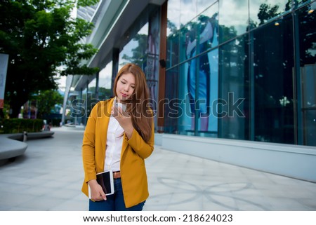 Businesswoman on cellphone running while talking on smart phone. Happy smiling mixed race Asian