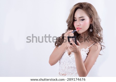 beautiful woman is applying her lips with pink lipstick,Woman with lipstick