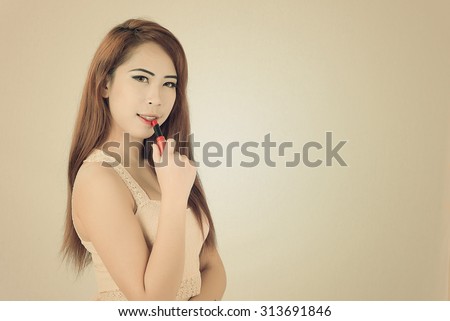 beautiful woman is applying her lips with pink lipstick,Woman with lipstick