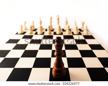 Black chess piece with a stretched perspective alone up against many white pieces. can stand for racism, challenge, adversity, diversity, courage,  or many other challenges in life.
