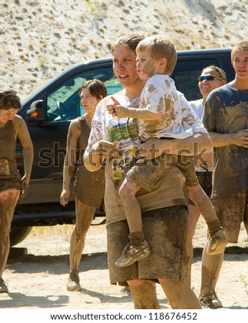 BOISE, IDAHO - AUGUST 25: Unidentified woman holding her child covered in mud at the Dirty Dash August 25 2012 in Boise, Idaho