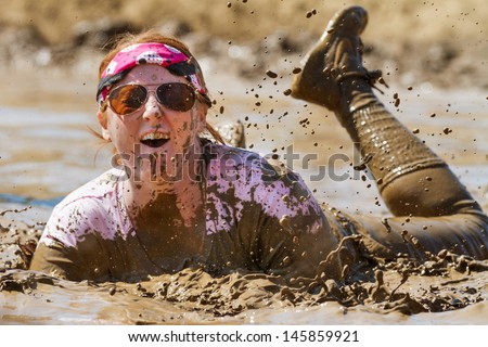 BOISE, IDAHO/USA - AUGUST 25 -  Woman playing in the mud at the dirty dash. The Dirty dash is a 10k run through obstacles and mud on August 25, 2012 in Boise, Idaho