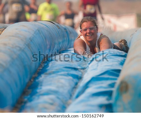 BOISE, IDAHO/USA - AUGUST 10: Unidentified woman slides face first down the slide at the The Dirty Dash in Boise, Idaho on August 10, 2013