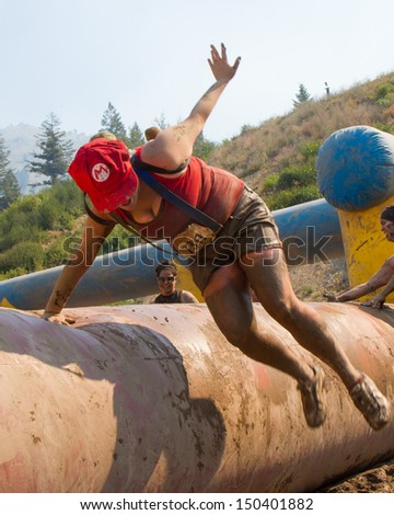 BOISE, IDAHO/USA - AUGUST 10:  Runner 7317 dressed in a Mario outfit jumps over and obstacle at the The Dirty Dash in Boise, Idaho on August 10, 2013