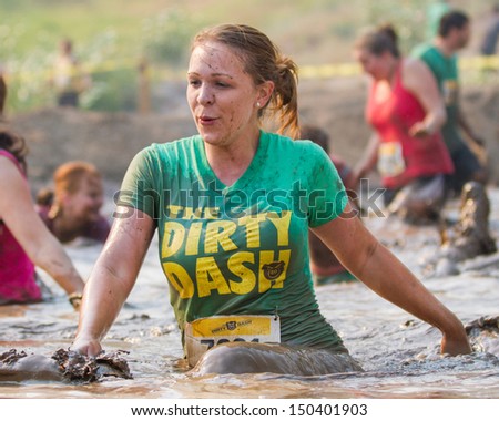 BOISE, IDAHO/USA - AUGUST 10: Woman makes a splash in the mud at the The Dirty Dash in Boise, Idaho on August 10, 2013