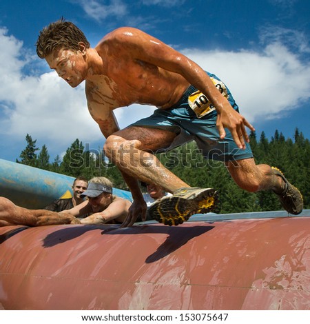 BOISE, IDAHO/USA - AUGUST 11: Unidentified runner jumps over an obstacle at the The Dirty Dash in Boise, Idaho on August 11, 2013