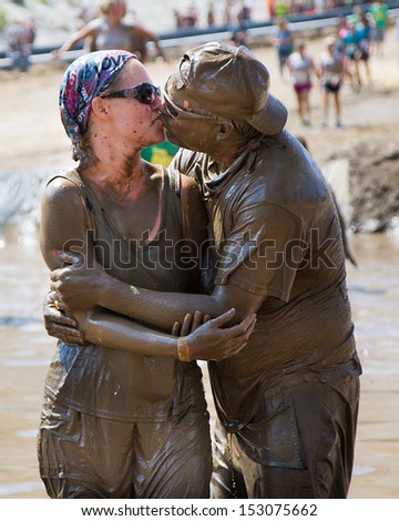 BOISE, IDAHO/USA - AUGUST 11: Two people kiss at the finish line while coverd in mud at the The Dirty Dash in Boise, Idaho on August 11, 2013