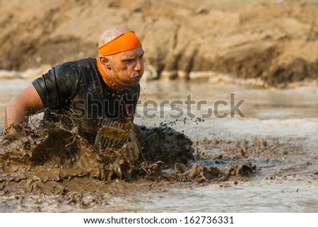 BOISE, IDAHO/USA - AUGUST 10:Runner 40119 splashes hard through the mud determined to finish at the The Dirty Dash in Boise, Idaho on August 10, 2013