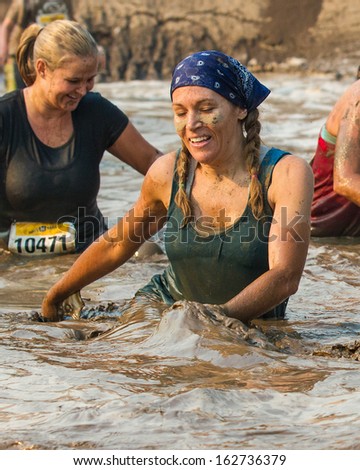 BOISE, IDAHO/USA - AUGUST 10:Unidentified woman makes a splash through the mud pit at the The Dirty Dash in Boise, Idaho on August 10, 2013
