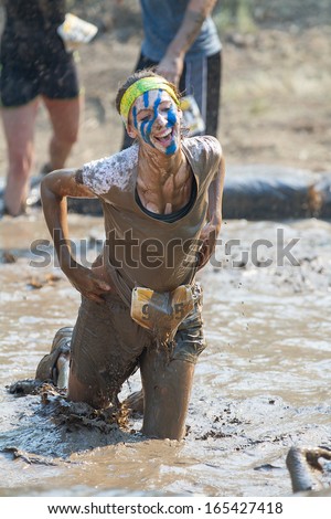 BOISE, IDAHO/USA - AUGUST 10: Unidentified woman kneels in the mud pit at the The Dirty Dash in Boise, Idaho on August 10, 2013