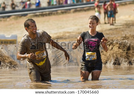 BOISE, IDAHO/USA - AUGUST 10, 2013: Runner 9738 and 9737 have fun at  at the mud pit during The Dirty Dash