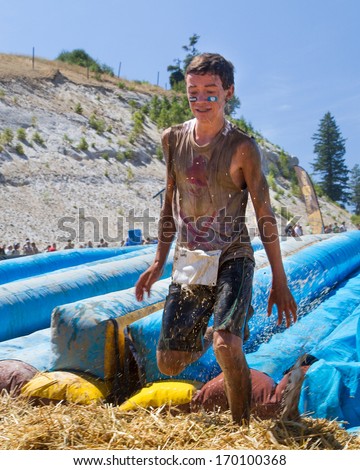 BOISE, IDAHO/USA - AUGUST 10, 2013: Runner works his way off the way after going down the big slide at the The Dirty Dash