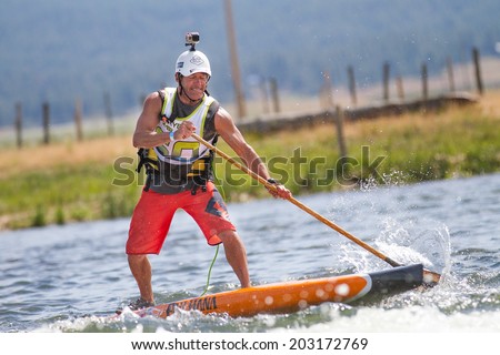 CASCADE, IDAHO/USA - JUNE 21, 2014: Man balances on his paddle board during the Payette River Games in Cascade, Idaho