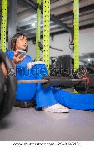 Similar – Image, Stock Photo Sportswoman using smartphone after training