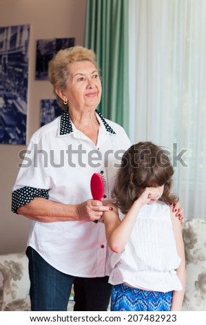 Nice elderly woman grandmother comforting crying granddaughter