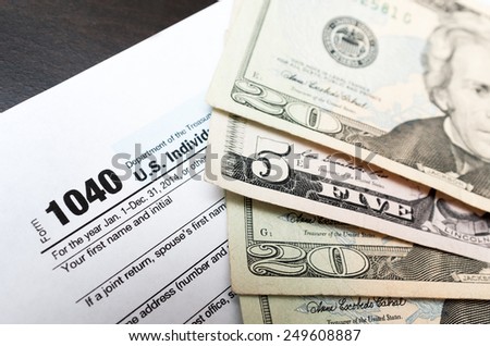 US Individual Tax Return Form 1040 with dollars bills