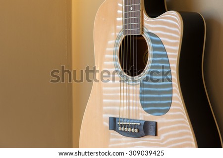 Acoustic guitar hanging on the wall close up