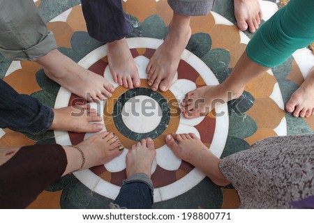 Feet forming a circle.  It is a image of people\'s feet forming a circle.
