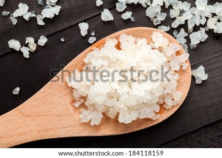 Water kefir grains into a wooden spoon on black wooden background