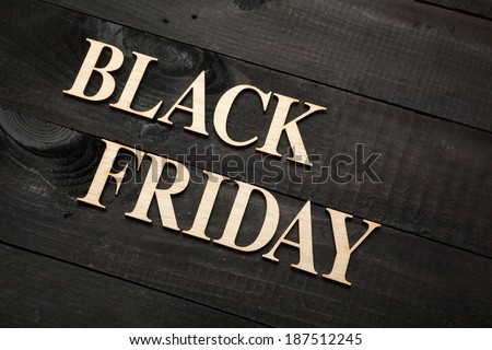 Wooden letters forming words BLACK FRIDAY written on black wooden background