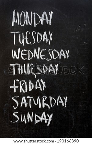 Conceptual weekdays list written on black chalkboard blackboard. Monday Tuesday Wednesday Thursday Friday Saturday Sunday.