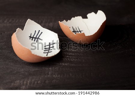 Escape from the egg. Broken egg of chicken that escaped from the egg. Isolated on black wooden background.