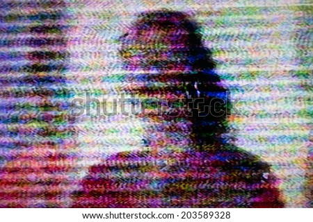 Human figure on television screen with static noise caused by bad signal reception