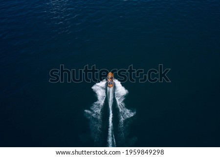 Classic Italian motor boat. Top view of a wooden boat sailing to the blue sea. Wooden runabout in the rays of the sun on blue water. Drone view of a boat the blue clear waters. Stock fotó © 