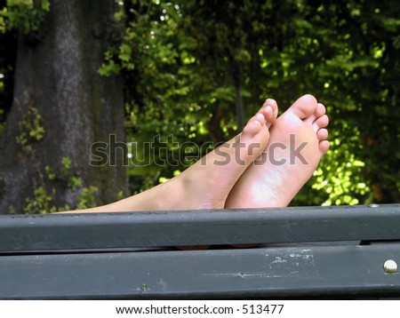woman feet while resting on a park bench,