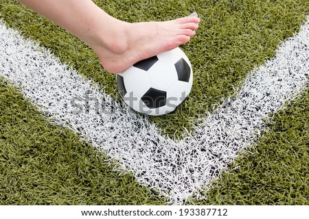 girl foot on the soccer ball on green field morning