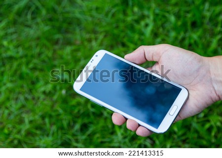 Close up man using mobile smart phone green background