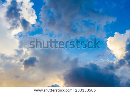 Dainty wispy pale salmon pink and golden yellow clouds at sunset  background