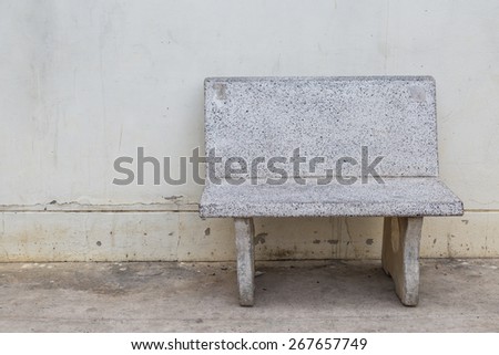empty grungy old stone chair on cement wall blackground