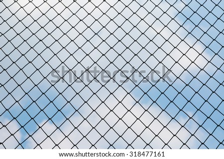 Silhouette of the steel fence barbed wire with blue sky background
