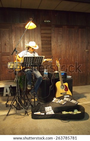 LOEI, THAILAND - 8 March: Man Playing Music on the street. The light in the evening on March 8, 2015 in Chiang Khan.