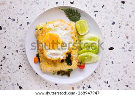 Fried rice plus  fried egg (Thai food) on the stone table (top view)
