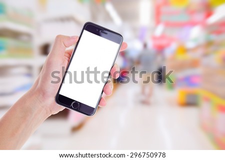 hand holding mobile smart phone on Supermarket blur background,Concept for sell shop on mobile phone