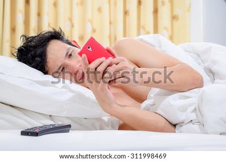 Social media addict,Men on bed not sleep because play smart phone