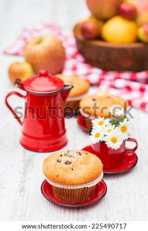 Apple and chocolate chips muffins with the vintage red enameled table ware on the white table