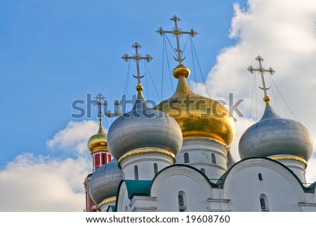 Against the blue sky with white clouds, a majestic temple with gold domes