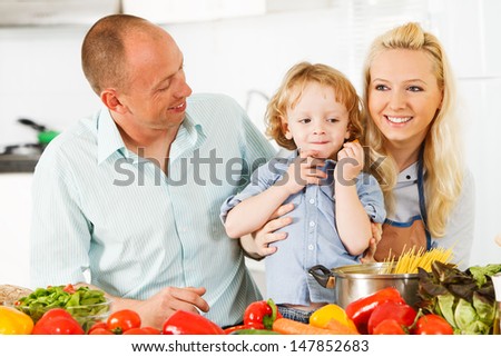 Happy family is preparing a healthy dinner in the kitchen.